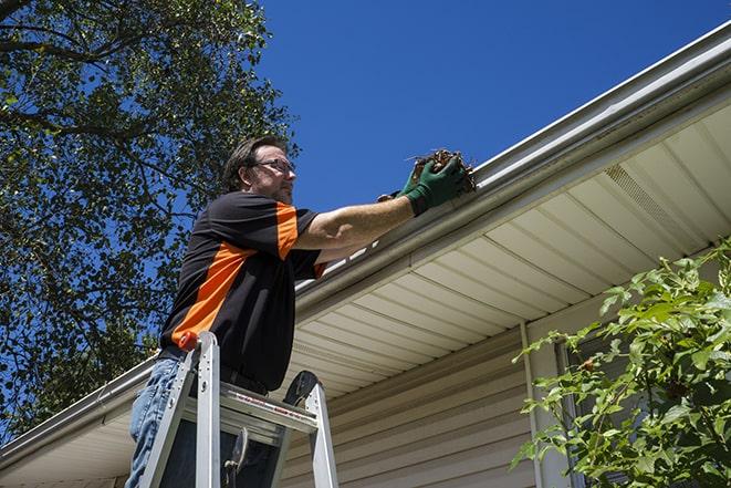 repairman sealing and reattaching a loose and sagging gutter in Bladensburg MD